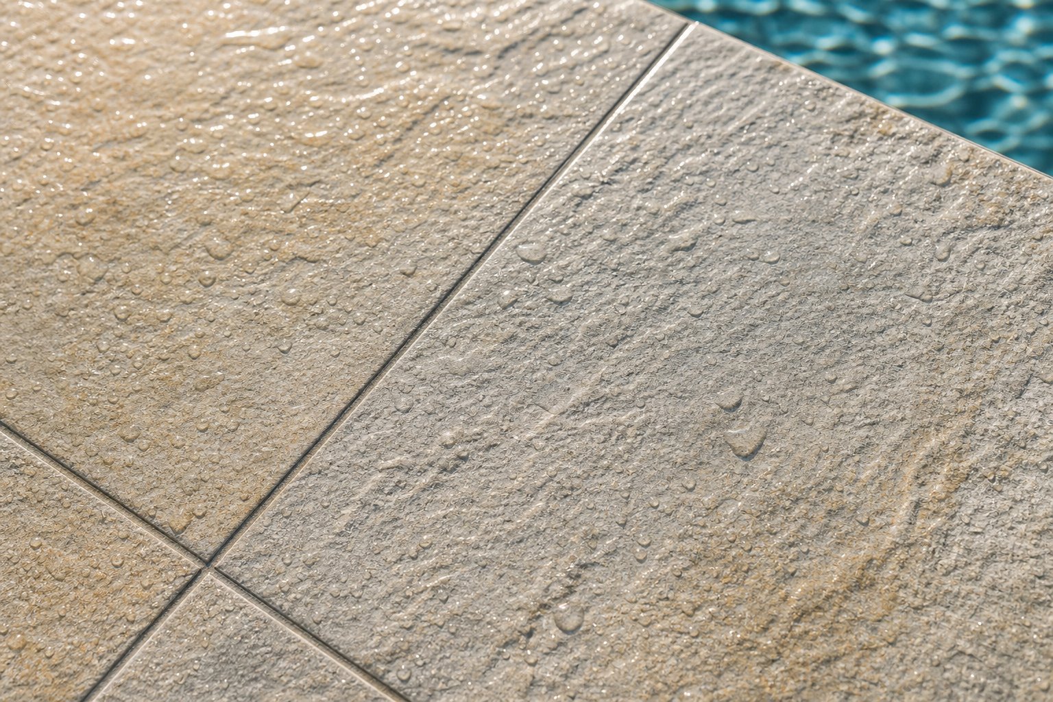 Close-up of slip-resistant textured porcelain pool deck tile with tight grout lines